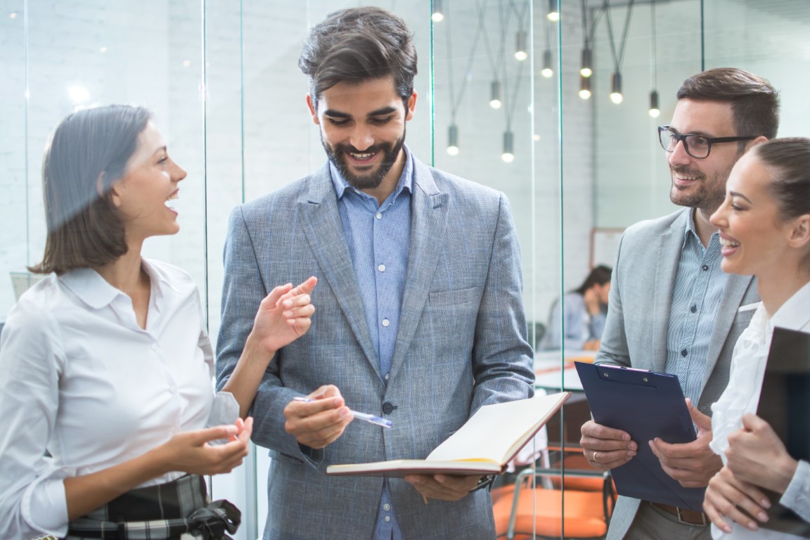 Business team discussing business documents, standing in the office lobby ecoinsight software plus